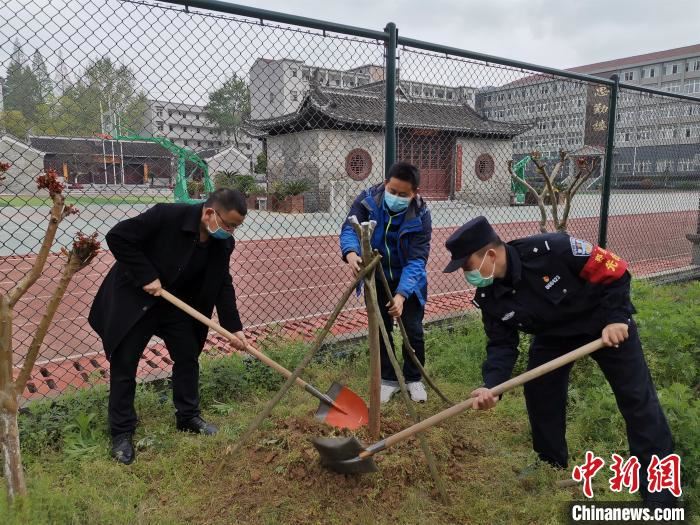 图为南漳民警和群众代表为郑勇种下“纪念林” 龚轩 摄