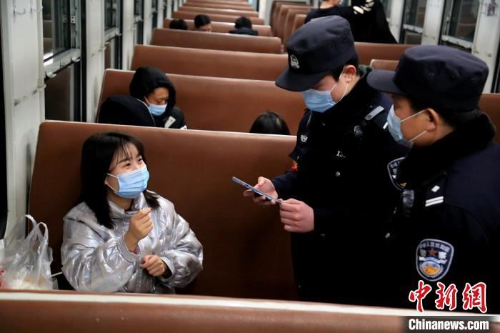 学警李德健在父亲李章龙的指导下对返乡旅客防疫信息进行调查。　郝黎俊 摄