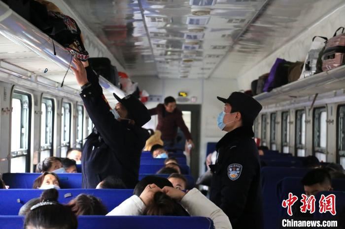 乘警李章龙带着“徒弟”在车厢排查安全隐患。　郝黎俊 摄